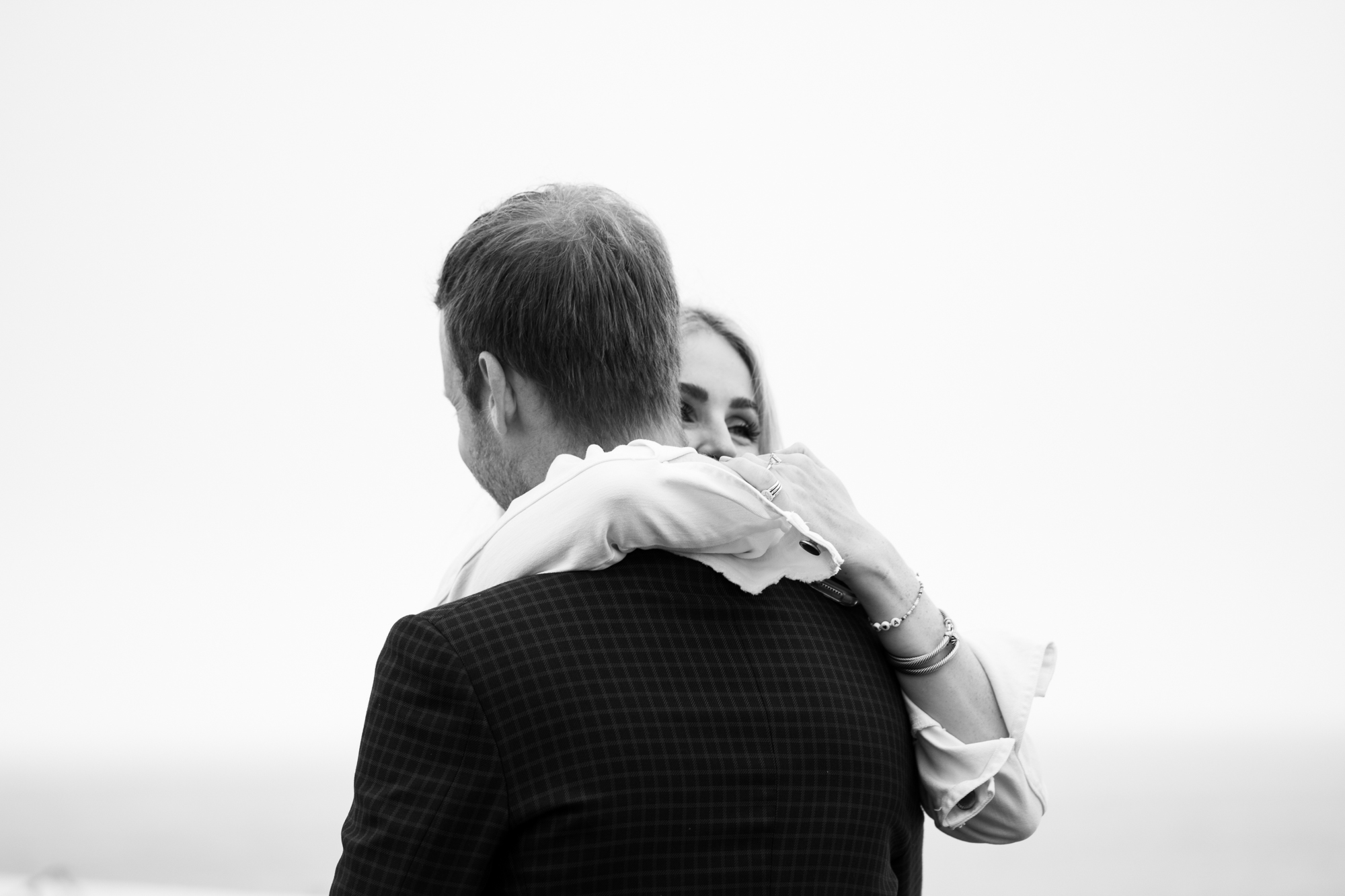 black and white photo couple hugging after wedding proposal