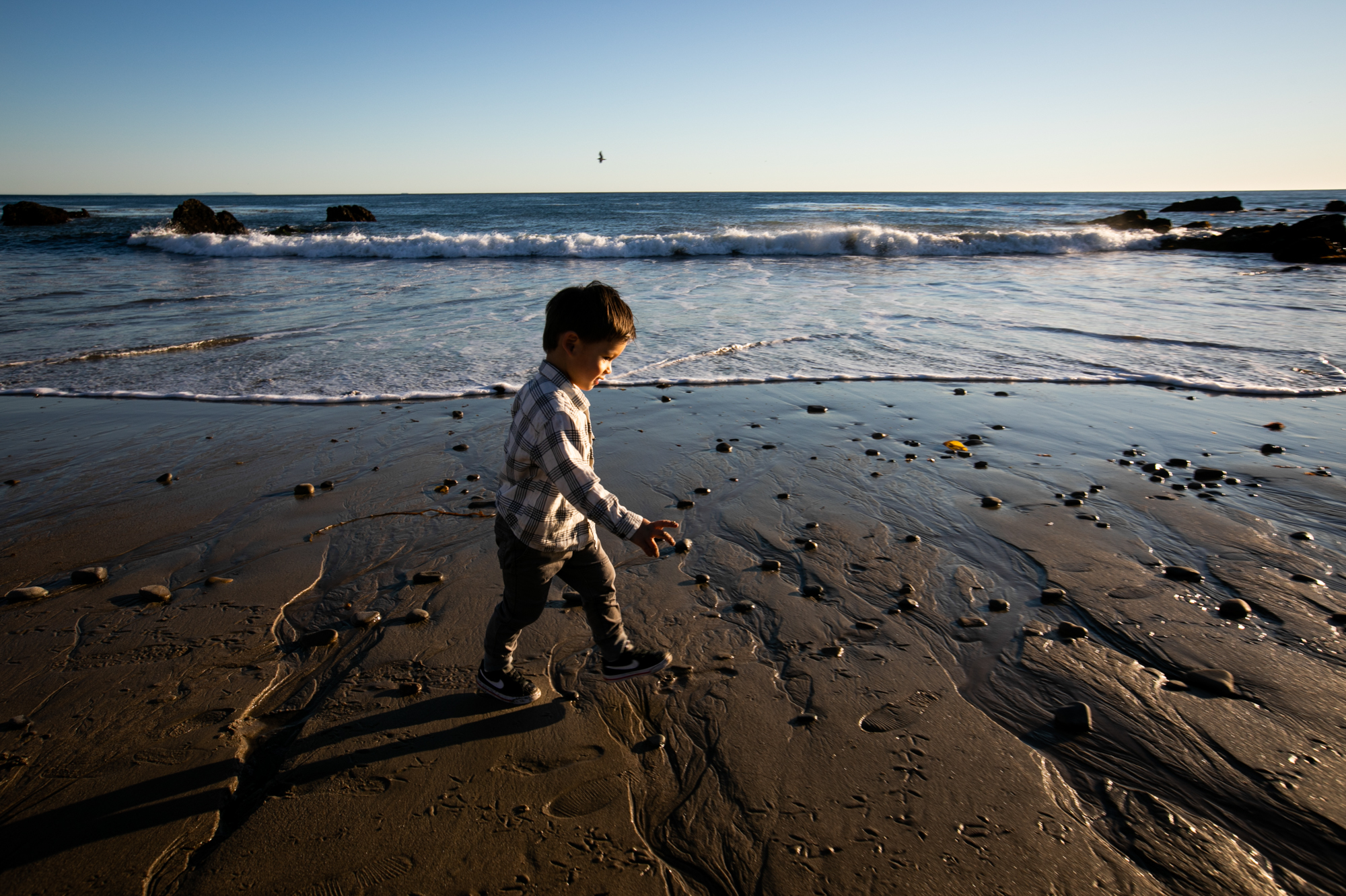 boy walks on beach in malibu